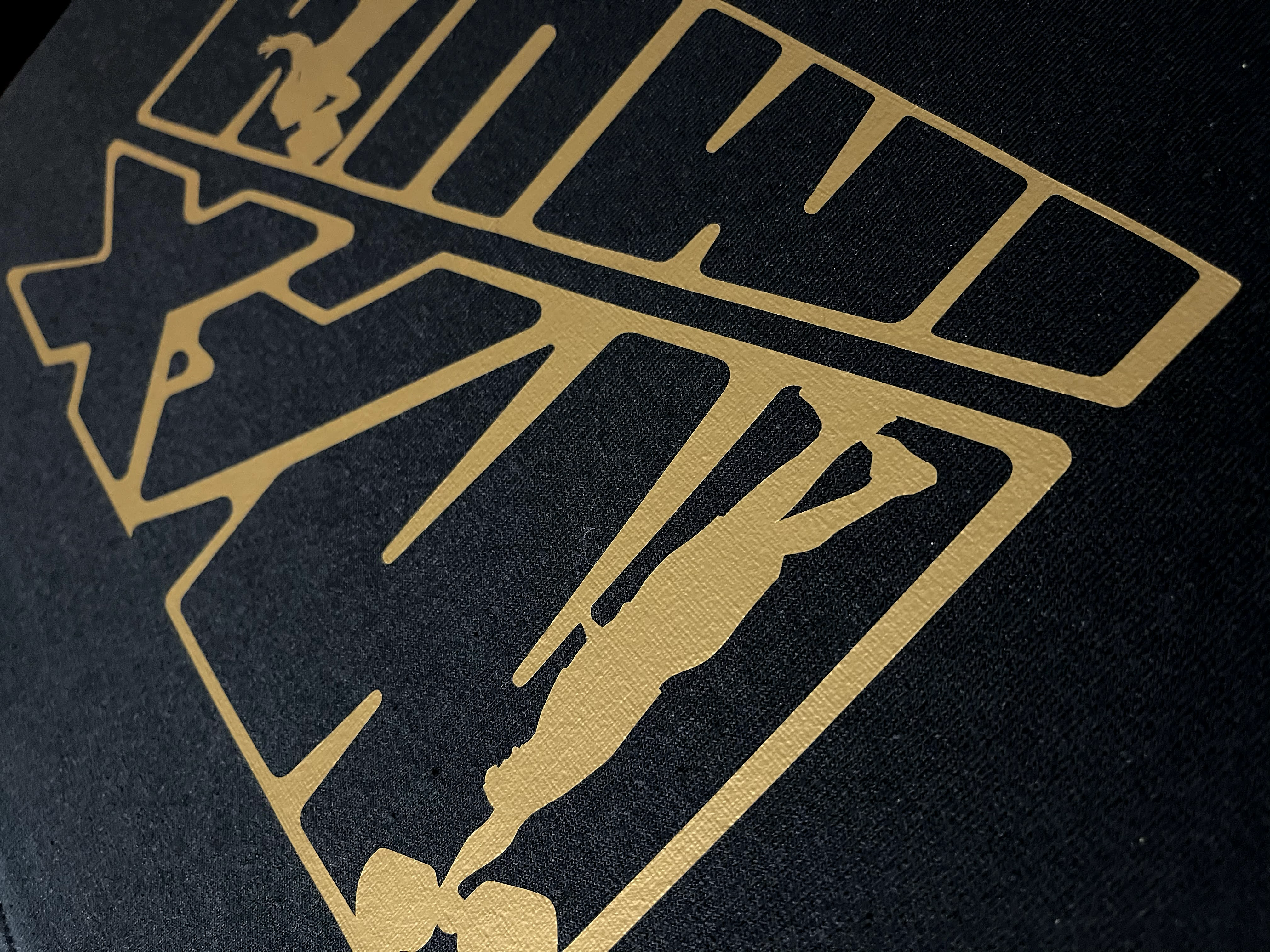 Close-up gold logo print on black apparel